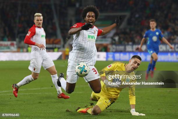 Caiuby of Augsburg is fouled by Koen Casteels of Wolfsburg during the Bundesliga match between FC Augsburg and VfL Wolfsburg at WWK-Arena on November...