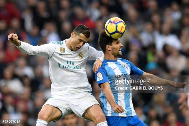 Real Madrid's Portuguese forward Cristiano Ronaldo jumps for the ball with Malaga's Spanish midfielder Adrian Gonzalez Morales during the Spanish...
