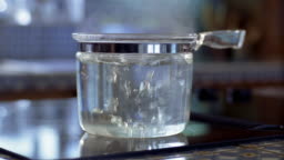 Medium Shot Dolly Shot Clear Glass Pot Of Water Boiling On Stove