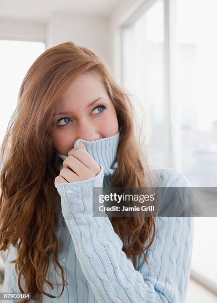 teenage girl hiding her face with sweater - shy fotografías e imágenes de stock