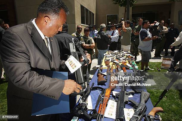 Special Agent in Charge John A. Torres handles one of about 125 weapons confiscated during what the federal authorities say is the largest gang...