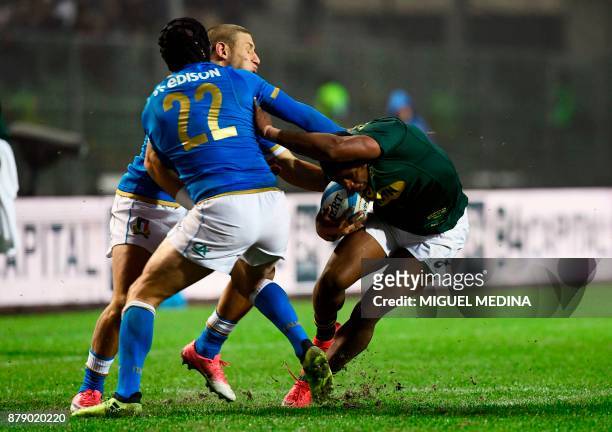 South Africa's fullback Warrick Gelant runs to evade Italy's fly-half Ian McKinley and Italy's fullback Matteo Minozzi during a rugby union test...
