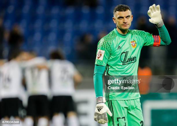 Vladimir Gabulov of FC Arsenal Tula reacts as FC Tosno players celebrate a goal in the background during the Russian Football League match between FC...