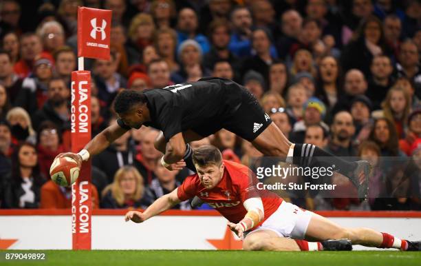 Waisake Naholo of New Zealand touches down for the first try while under pressure from Steff Evans of Wales during the International match between...