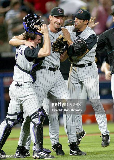 Arizona's Randy Johnson shows his excitement as he hugs teammates Robby Hammick and Alex Cintron after pitching a perfect game against Atlanta May 18...