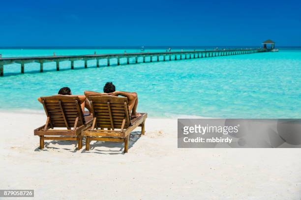 couple enjoying holidays at dhiffushi holiday island, maldives - beach holiday stock pictures, royalty-free photos & images