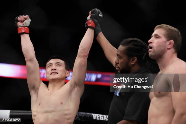 Song Kenan of China, left, celebrates after his victory over Bobby Nash, right, during the UFC Fight Night at Mercedes-Benz Arena on November 25,...