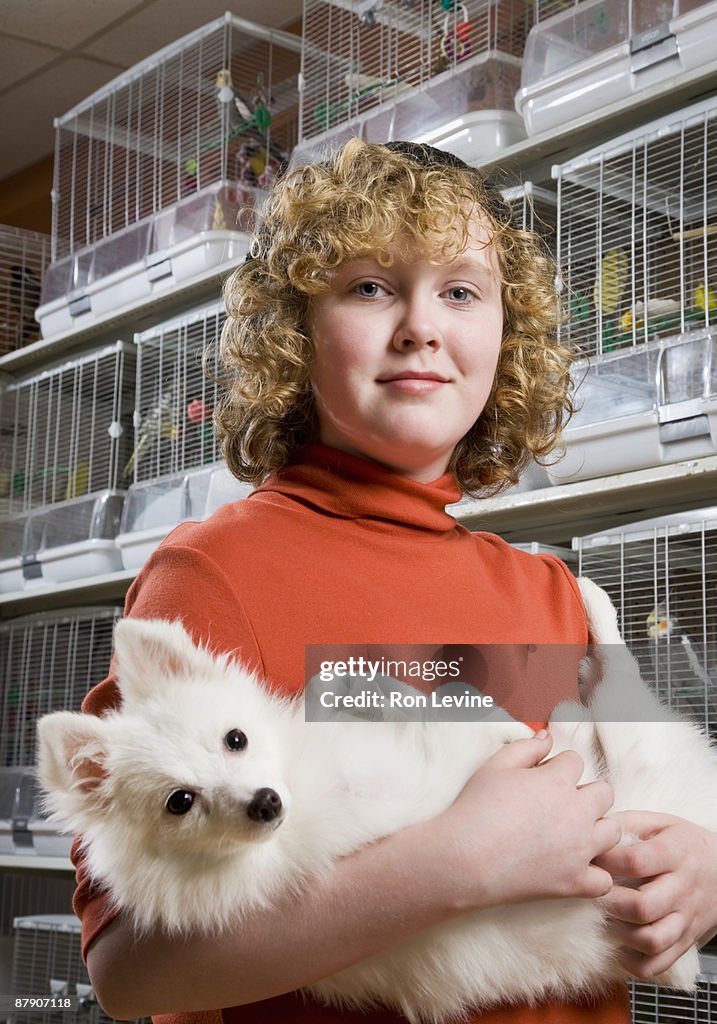 Young girl holding puppy in a pet shop