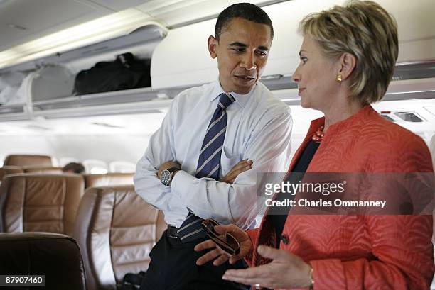 Presidential candidate Senator Barack Obama and Senator Hillary Rodham Clinton work their cellphones and chat together on his campaign plane at...