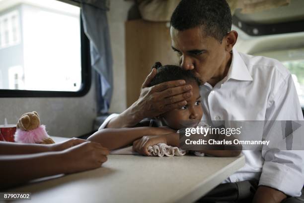 Democratic presidential hopeful Barack Obama, his wife Michelle and two daughters Sasha and Malia play cards in their RV, July 4, 2007 on a campaign...