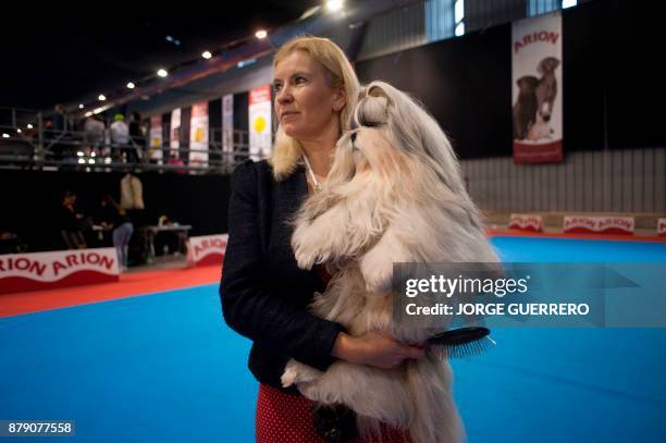 Woman holds her dog during the sixth edition of the "Mi Mascota" fair in Malaga on November 25, 2017. / AFP PHOTO / JORGE GUERRERO