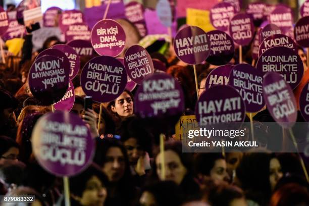 Protesters hold placards as they march during a demonstration to mark the International Day for the Elimination of Violence Against Women on November...