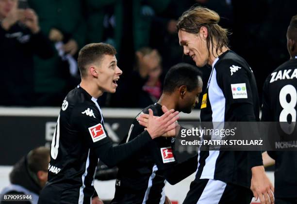 Moenchengladbach's Danish defender Jannik Vestergaard congratulates his teammate Belgian midfielder Thorgan Hazard after he scored a goal during the...
