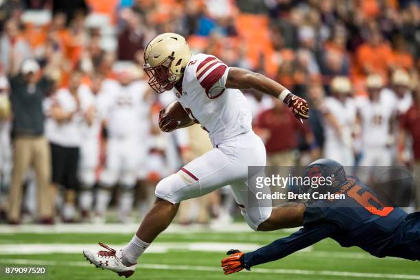 Dillon of the Boston College Eagles hurdles to avoid a tackle by Rodney Williams of the Syracuse Orange on a touchdown carry during the first quarter...