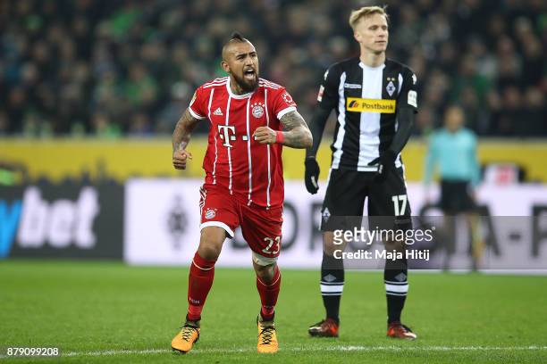 Arturo Vidal of Bayern Muenchen as Oscar Wendt of Moenchengladbach looks on celebrates after he scored a goal to make it 2:1 during the Bundesliga...