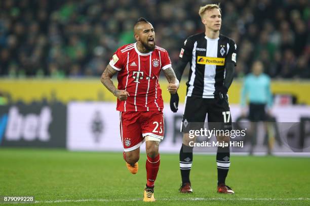 Arturo Vidal of Bayern Muenchen as Oscar Wendt of Moenchengladbach looks on celebrates after he scored a goal to make it 2:1 during the Bundesliga...