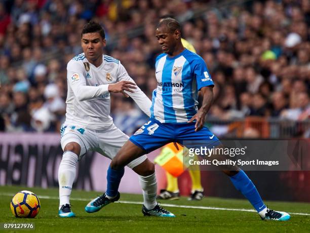 Diego Rolan of Malaga CF competes for the ball with Carlos Casemiro of Real Madrid during the La Liga match between Real Madrid and Malaga at Estadio...