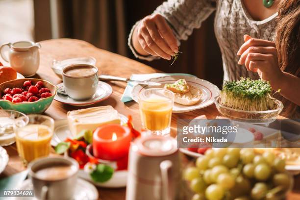 zeigen am frühstückstisch an - sonntag stock-fotos und bilder