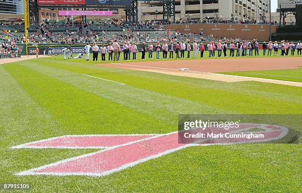 Pink ribbon is painted on the field to show support of the 'Going To Bat Against Breast Cancer' promotion during the game between the Detroit Tigers...