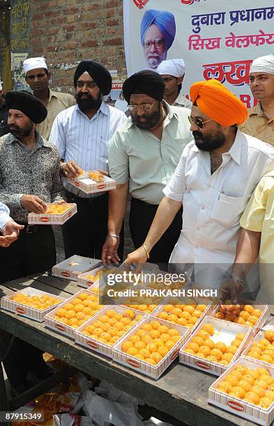 Members of Sikhs Welfare Society distribute sweets to celebrate the second term of Prime Ministership for Manmohan Singh at Gurudwara Racab Ganj in...