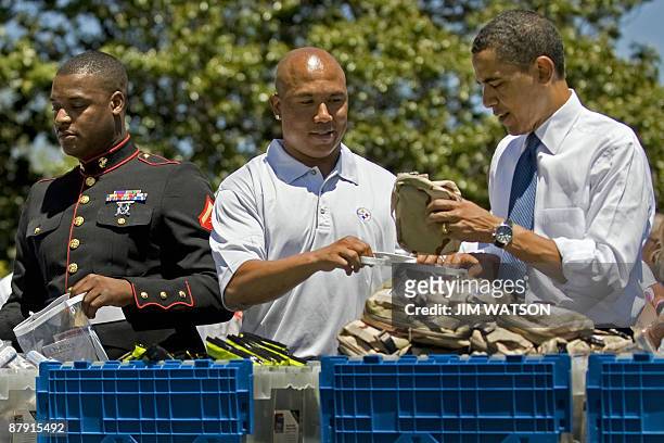 President Barack Obama packs USO care packages with Pittsburg Steelers Wide receiver Hines Ward during a service event on the South Lawn of the White...