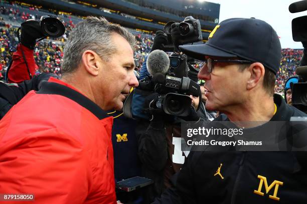 Urban Meyer head coach of the Ohio State Buckeyes and Jim Harbaugh head coach of the Michigan Wolverines shake hands after the game. Ohio State won...