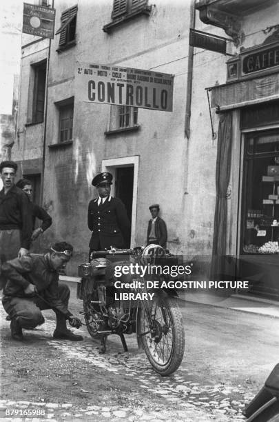 Driver inflating the tyre of his motorcycle at a checkpoint, Radio Auto Motorcycle Rally, June 29 Genoa, Italy, 20th century.