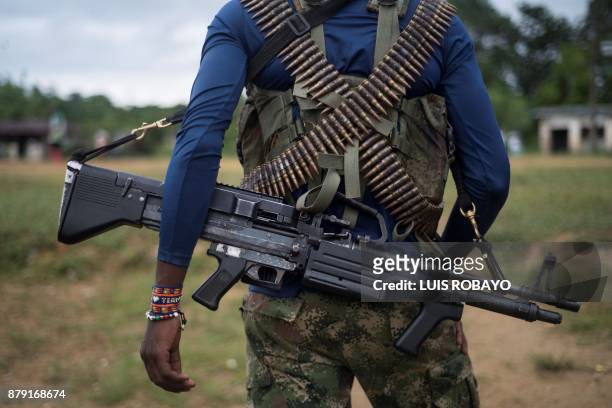 Member of the "Omar Gomez" Western War Front of the National Liberation Army guerrilla carries his machine gun in a camp on the banks of the San Juan...