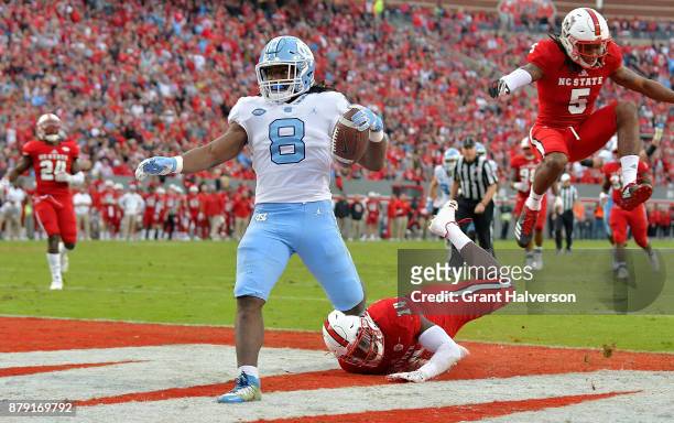 Michael Carter of the North Carolina Tar Heels beats Dexter Wright of the North Carolina State Wolfpack for a touchdown during their game at Carter...