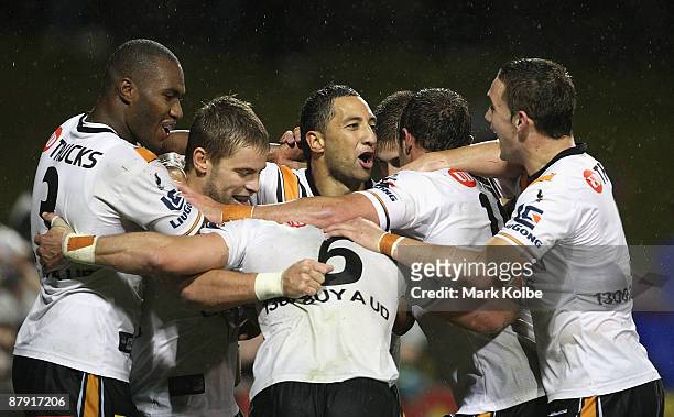 Benji Marshall of the Tigers is congratulated by his team mates after scoring a try during the round 11 NRL match between the Wests Tigers and the...
