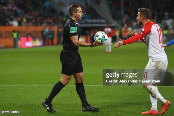 Referee Tobias Stieler reacts with Daniel Baier of Augsburg during the Bundesliga match between FC Augsburg and VfL Wolfsburg at WWK-Arena on...