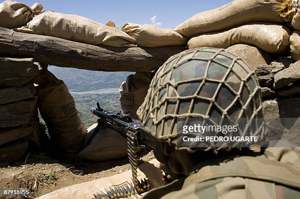 Pakistani soldier aims his weapon on top of a mountain overlooking the Swat valley at Banai Baba Ziarat area in northwest Pakistan on May 22, 2009....