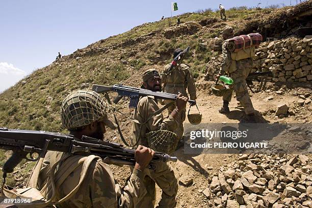 Pakistani soldiers walk to their positions on top of a mountain at Banai Baba Ziarat area in northwest Pakistan on May 22, 2009. The army took...