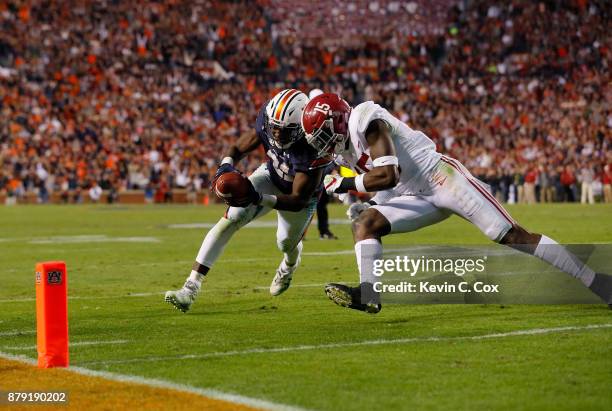 Kerryon Johnson of the Auburn Tigers is hit by Ronnie Harrison of the Alabama Crimson Tide diving towards the endzone during the third quarter of...