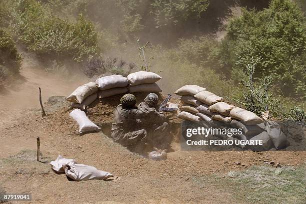 Pakistani soldiers take cover as an helicopter takes off from the top of a mountain at Banai Baba Ziarat area in northwest Pakistan on May 22, 2009....