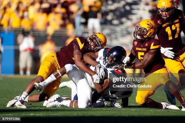 Defensive back Chad Adams and defensive back Kobe Williams of the Arizona State Sun Devils tackle wide receiver Tyrell Johnson of the Arizona...