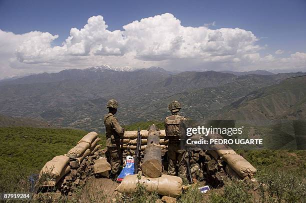 Pakistani soldiers stand guard on top of a mountain overlooking the Swat valley at Banai Baba Ziarat area in northwest Pakistan on May 22, 2009. The...