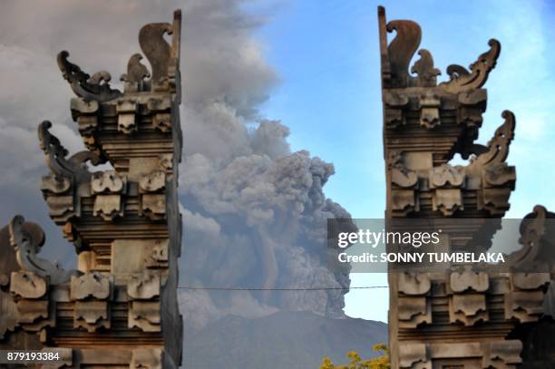 Mount Agung's eruption is seen between Balinese temple at Kubu sub-district in Karangasem Regency on Indonesia's resort island of Bali on November...
