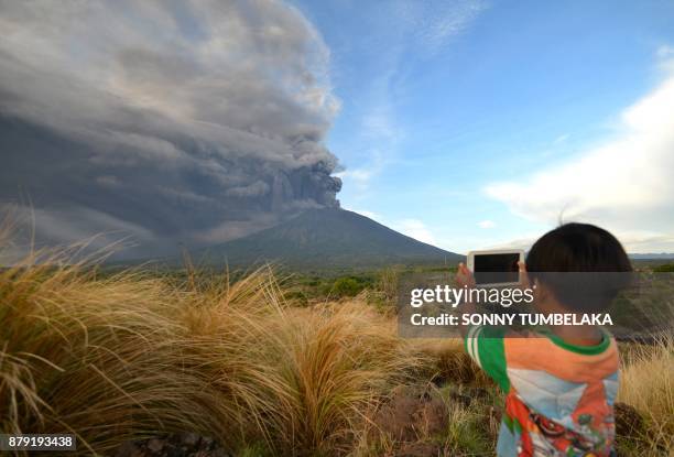 Boy takes pictures during Mount Agung's eruption seen from Kubu sub-district in Karangasem Regency on Indonesia's resort island of Bali on November...