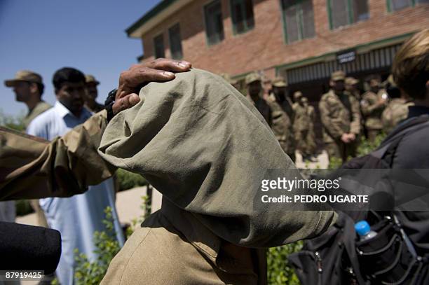 Soldier holds an alleged Taliban militant as he is presented to journalists inside an army base in Khwazakhela on May 22, 2009. Two days ago the...