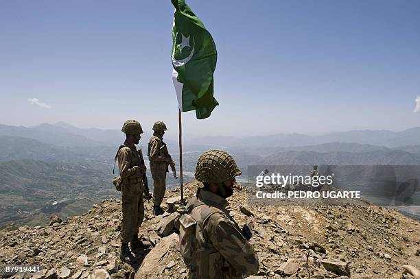 Pakistani soldiers stand guard on top of a mountain overlooking the Swat valley at Banai Baba Ziarat area in northwest Pakistan on May 22, 2009. The...