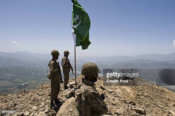 Pakistani soldiers stand guard on top of a mountain overlooking the Swat valley at Banai Baba Ziarat area on May 22, 2009 in northwest Pakistan....