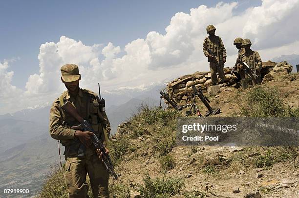 Pakistani soldiers stand guard on top of a mountain overlooking the Swat valley at Banai Baba Ziarat area on May 22, 2009 in northwest Pakistan....