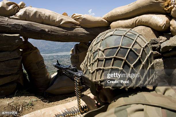 Pakistani soldier aims his weapon on top of a mountain overlooking the Swat valley at Banai Baba Ziarat area on May 22, 2009 in northwest Pakistan....