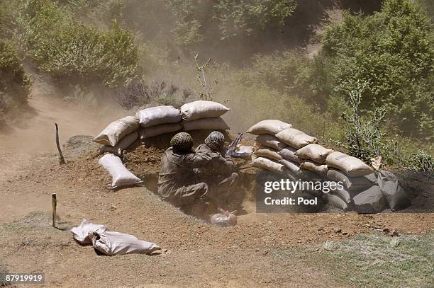 Pakistani soldiers take cover as a helicopter takes off from the top of a mountain on May 22, 2009 at Banai Baba Ziarat area in northwest Pakistan....