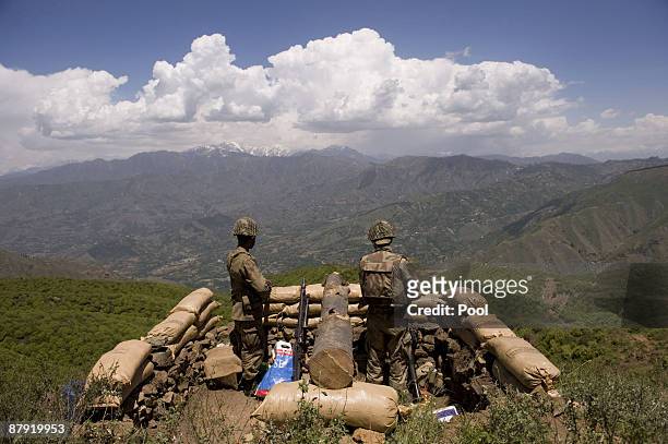 Pakistani soldiers stand guard on top of a mountain overlooking the Swat valley at Banai Baba Ziarat area on May 22, 2009 in northwest Pakistan....