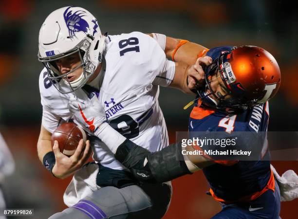 Clayton Thorson of the Northwestern Wildcats runs the ball as Bennett Williams of the Illinois Fighting Illini tries to make the tackle at Memorial...