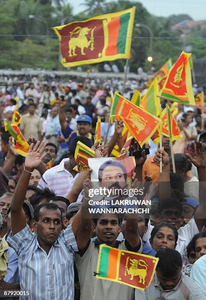 Sri Lankans wave national flags as unseen President Mahinda Rajapakse arrives at a festival to celebrate the defeat of the Tamil Tiger rebels in...