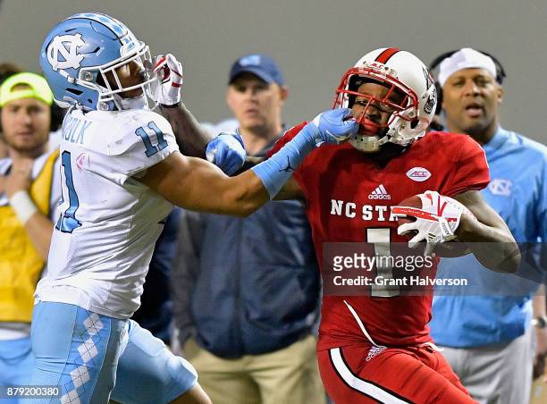Myles Wolfolk of the North Carolina Tar Heels is called for a facemask penalty against Jaylen Samuels of the North Carolina State Wolfpack during...