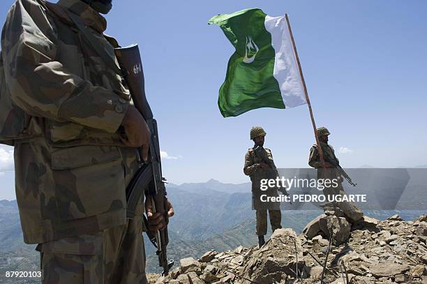 Pakistani soldiers stand guard on top of a mountain overlooking the Swat valley at Banai Baba Ziarat area in northwest Pakistan on May 22, 2009. The...